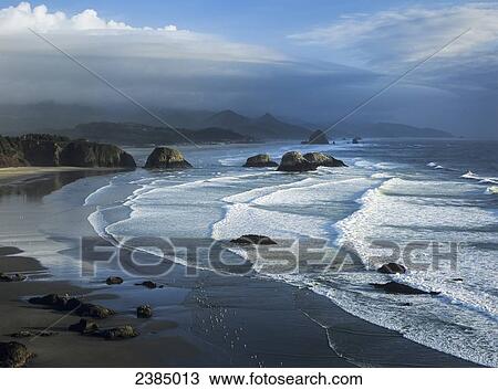 Stock Image - Waves wash onto Crescent Beach; Cannon Beach, Oregon, United States of America. Fotosearch