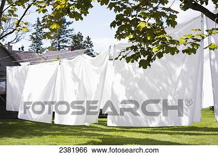 Stock Photograph - White sheets drying on a clothesline outside; Charelvoix, Quebec, Canada. Fotosearch