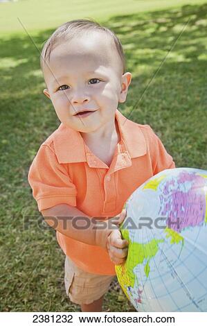 Young boy holding a globe at the park; Honolulu, Oahu, Hawaii, United States of America View Large Photo Image Stock Image - Young boy holding a globe at the park; Honolulu, Oahu, Hawaii, United States of America. Fotosearch