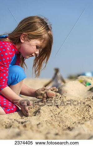 Young girl covering up persons feet lying on a sandy beach; Dubai, United Arab Emirates View Large Photo Image Stock Photography - Young girl covering up persons feet lying on a sandy beach; Dubai, United Arab Emirates. Fotosearch