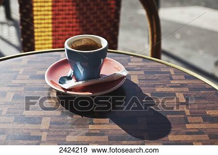 A cup of coffee sitting on a table at a cafe; Paris, France View Large Photo Image Stock Photo - A cup of coffee sitting on a table at a cafe; Paris, France. Fotosearch