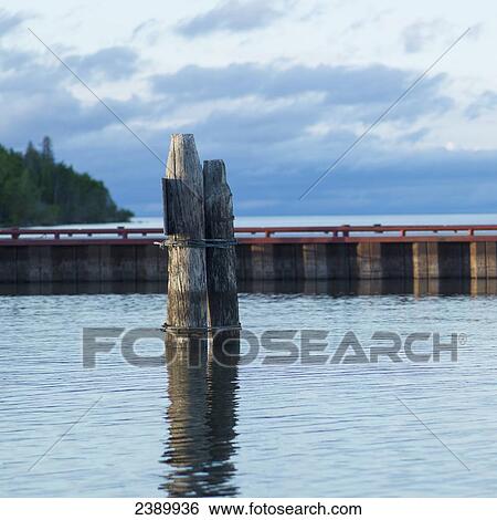 A dock and wooden posts in the water at Hecla-Grindstone Provincial Park; Riverton, Manitoba, Canada View Large Photo Image Stock Photograph - A dock and wooden posts in the water at Hecla-Grindstone Provincial Park; Riverton, Manitoba, Canada. Fotosearch