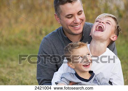 A father playing with his two sons in a park in autumn; Edmonton, Alberta, Canada View Large Photo Image Picture - A father playing with his two sons in a park in autumn; Edmonton, Alberta, Canada. Fotosearch