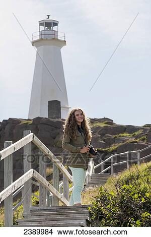 A girl with her camera stands on steps leading to a lighthouse; St. John's, Newfoundland and Labrador, Canada View Large Photo Image Picture - A girl with her camera stands on steps leading to a lighthouse; St. John's, Newfoundland and Labrador, Canada. Fotosearch
