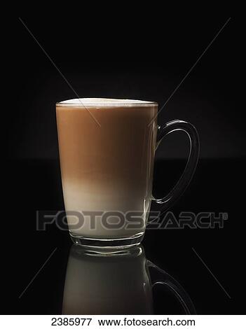 A glass mug with a foamy coffee drink against a black background View Large Photo Image Stock Photo - A glass mug with a foamy coffee drink against a black background. Fotosearch