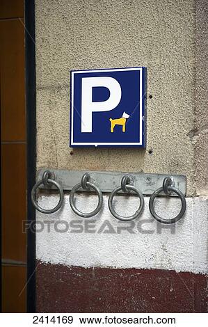 Stock Photo - A humorous sign for parking, or tethering, your pet to a metal ring on the wall; Barcelona, Spain. Fotosearch
