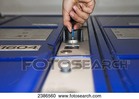 Stock Image - A key opening a lock to a locker in a train station; Zurich, Switzerland. Fotosearch