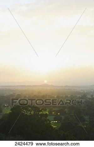 A lush landscape of trees with mountains in the distance at sunset; Ulpotha, Embogama, Sri Lanka View Large Photo Image Stock Photo - A lush landscape of trees with mountains in the distance at sunset; Ulpotha, Embogama, Sri Lanka. Fotosearch