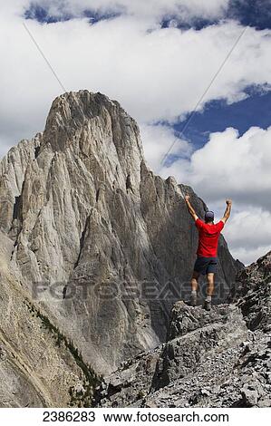 A man stands on a rugged rocky ridge with arms raised; Banff, Alberta, Canada View Large Photo Image Stock Image - A man stands on a rugged rocky ridge with arms raised; Banff, Alberta, Canada. Fotosearch