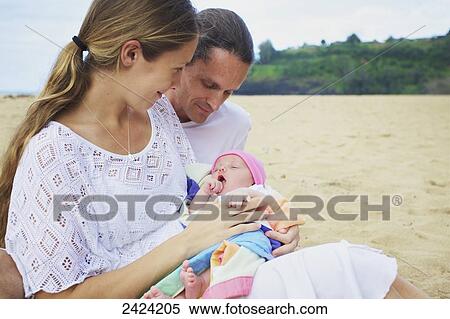 A mother and father with their newborn daughter on the beach; Kauai, Hawaii, United States of America View Large Photo Image Stock Photography - A mother and father with their newborn daughter on the beach; Kauai, Hawaii, United States of America. Fotosearch