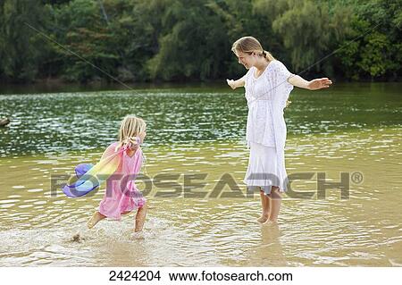 A mother plays in the shallow water off the beach with her young daughter; Kauai, Hawaii, United States of America View Large Photo Image Picture - A mother plays in the shallow water off the beach with her young daughter; Kauai, Hawaii, United States of America. Fotosearch