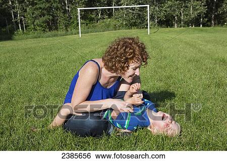 A mother plays with her son on the grass; Stony Plain, Alberta, Canada View Large Photo Image Stock Photograph - A mother plays with her son on the grass; Stony Plain, Alberta, Canada. Fotosearch