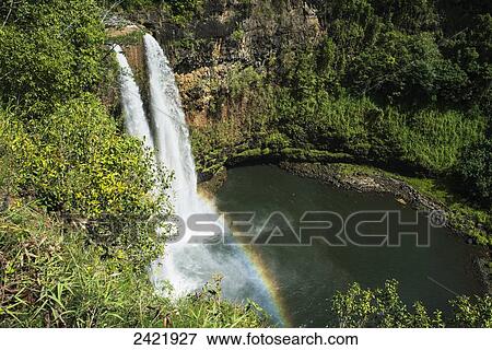 Stock Photo - A rainbow adorns Wailua Falls; Kauai, Hawaii, United States of America. Fotosearch