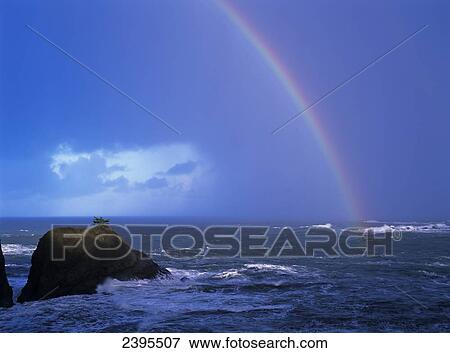 Stock Photo - A rainbow brightens the sky over the ocean; Charleston, Oregon, United States of America. Fotosearch