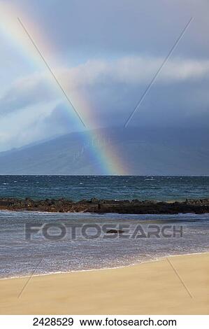 Stock Photo - A rainbow forms along Kamaole 3 Beach; Maui, Hawaii, United States of America. Fotosearch