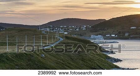 Stock Image - A road along the atlantic coast leading to a coastal village at sunset; Calvert, Newfoundland and Labrador, Canada. Fotosearch