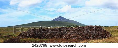 A rock pile with a mountain peak in the distance; Doogort, Achill Island, County Kerry, Ireland View Large Photo Image Stock Photo - A rock pile with a mountain peak in the distance; Doogort, Achill Island, County Kerry, Ireland. Fotosearch