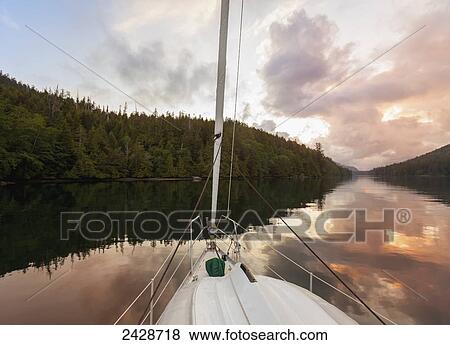 A sailboat at anchor in the setting sun on the west coast of Vancouver Island; Duncan, British Columbia, Canada View Large Photo Image Stock Photo - A sailboat at anchor in the setting sun on the west coast of Vancouver Island; Duncan, British Columbia, Canada. Fotosearch