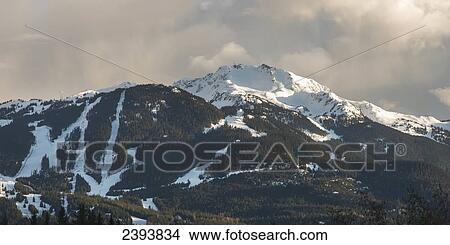 A snow capped mountain under a cloudy sky; Whistler, British Columbia, Canada View Large Photo Image Picture - A snow capped mountain under a cloudy sky; Whistler, British Columbia, Canada. Fotosearch
