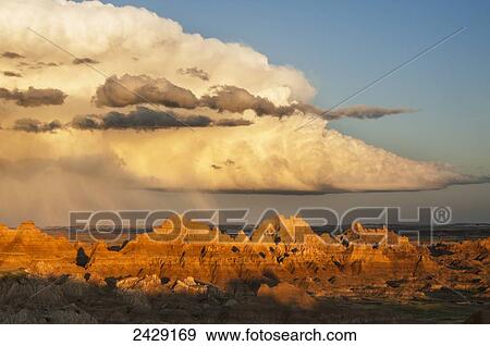A summer rain storm hovers over formations in Cedar Pass, Badlands National Park; South Dakota, United States of America View Large Photo Image Stock Photo - A summer rain storm hovers over formations in Cedar Pass, Badlands National Park; South Dakota, United States of America. Fotosearch