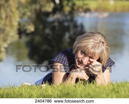 A woman on the grass in a park crying; Edmonton, Alberta, Canada View Large Photo Image Stock Photograph - A woman on the grass in a park crying; Edmonton, Alberta, Canada. Fotosearch