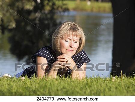 A woman on the grass in a park in prayer; Edmonton, Alberta, Canada View Large Photo Image Stock Photo - A woman on the grass in a park in prayer; Edmonton, Alberta, Canada. Fotosearch