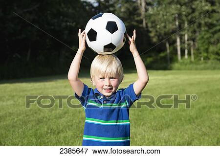 A young boy holding a soccer ball on his head at a park; Stony Plain, Alberta, Canada View Large Photo Image Stock Photo - A young boy holding a soccer ball on his head at a park; Stony Plain, Alberta, Canada. Fotosearch