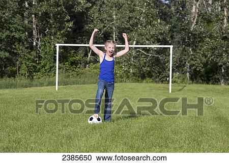 Stock Image - A young girl gives a cheer on the soccer field; Stony Plain, Alberta, Canada. Fotosearch