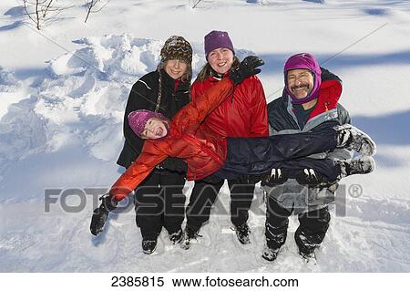 Stock Photography - A young girl with three adults playing in the snow; Talkeetna, Alaska, United States of America. Fotosearch