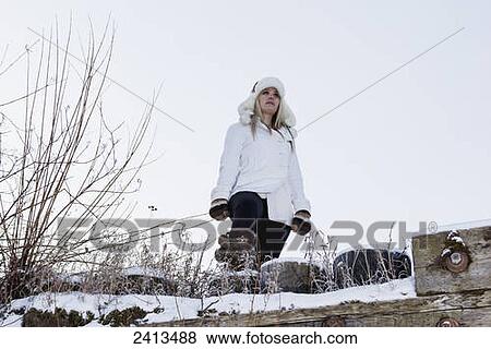 A young woman in winter fashion attire stands on a ledge in winter; Fort McMurray, Alberta, Canada View Large Photo Image Stock Photo - A young woman in winter fashion attire stands on a ledge in winter; Fort McMurray, Alberta, Canada. Fotosearch