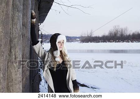 A young woman wearing winter attire poses near a frozen river in the snow; Fort McMurray, Alberta, Canada View Large Photo Image Stock Photo - A young woman wearing winter attire poses near a frozen river in the snow; Fort McMurray, Alberta, Canada. Fotosearch