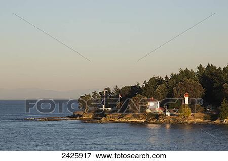 Active Pass Lighthouse on Northern tip of Mayne Island in the Strait Of Georgia where the ferry passes by on the way to Swartz Bay on Vancouver Island; British Columbia, Canada View Large Photo Image Stock Photo - Active Pass Lighthouse on Northern tip of Mayne Island in the Strait Of Georgia where the ferry passes by on the way to Swartz Bay on Vancouver Island; British Columbia, Canada. Fotosearch