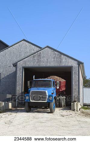 Stock Photo - Agriculture - A truck waits in the packing shed for its load of potatoes to be unloaded for cleaning and sorting at a local family produce farm / Little Compton, Rhode Island, USA.. Fotosearch