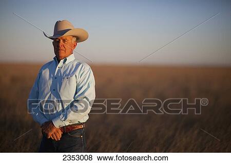 Stock Photo - Agriculture - Cowboy standing in a conservation reserve program (CRP) field / Floydada, Texas, USA.. Fotosearch