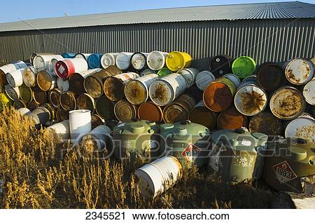 Agriculture - Old empty chemical drums and containers stacked up behind a shed on a farm / Minnesota, USA. View Large Photo Image Stock Image - Agriculture - Old empty chemical drums and containers stacked up behind a shed on a farm / Minnesota, USA.. Fotosearch