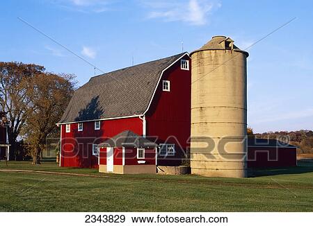 Stock Photo - Agriculture - Red barn and silo in Autumn with green lawn in the foreground / Waterford, Wisconsin, USA.. Fotosearch