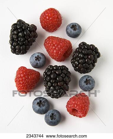 Picture - Agriculture - Red raspberries, blackberries and blueberries on a white surface.. Fotosearch