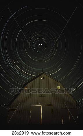 Stock Photo - Agriculture - Unique photo of the night time sky above a barn. The barn is below the north star so the star trails create a circle above the barn in this 6 hour exposure / Northwest Missouri, USA.. Fotosearch