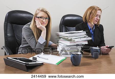 Stock Photograph - An accounting intern looking overwhelmed by a pile of paperwork; Edmonton, Alberta, Canada. Fotosearch - Search Stock Photography, Posters, Pictures, and Photo Clipart Images