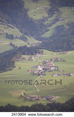 An alpine village in a valley with green meadows, rolling hills with trees in autumn; Brandenburg, Austria View Large Photo Image Picture - An alpine village in a valley with green meadows, rolling hills with trees in autumn; Brandenburg, Austria. Fotosearch