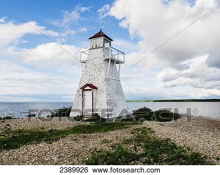 Stock Photograph - An old white lighthouse on the shore of Lake Winnipeg in Hecla-Grindstone Provincial Park; Manitoba, Canada. Fotosearch