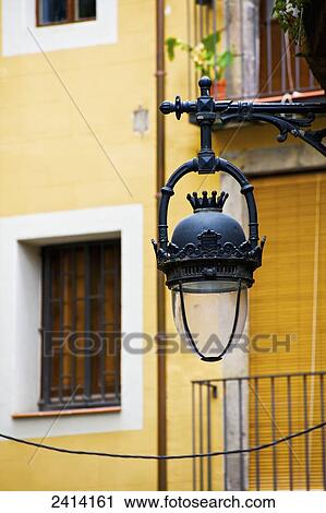 Stock Image - An ornate lamp hanging from a building; Barcelona, Spain. Fotosearch
