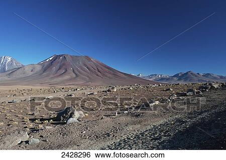 Stock Photograph - Arid landscape with mountains and blue sky, Antiplano; San Pedro de Atacama, Chile. Fotosearch