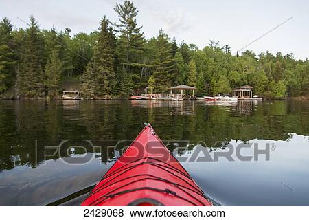 Bow of a canoe on a tranquil lake and a dock along the shore; Ontario, Canada View Large Photo Image Stock Photo - Bow of a canoe on a tranquil lake and a dock along the shore; Ontario, Canada. Fotosearch