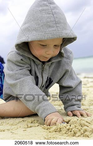 Stock Photo - Boy Playing In Sand On The Beach, Camaguey, Cuba. Fotosearch