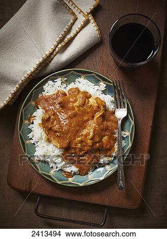 Picture - Butter chicken and rice on a plate. Fotosearch