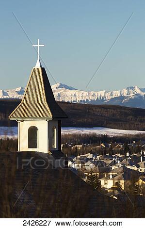 Church steeple with white cross and snow covered mountains and blue sky in the background; Calgary, Alberta, Canada View Large Photo Image Stock Photo - Church steeple with white cross and snow covered mountains and blue sky in the background; Calgary, Alberta, Canada. Fotosearch