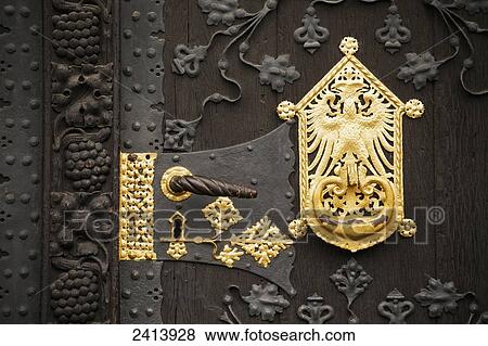 Close up of gold ornament on large wooden door with decorative metal carvings and door handle; Frankfurt am Main, Germany View Large Photo Image Stock Photo - Close up of gold ornament on large wooden door with decorative metal carvings and door handle; Frankfurt am Main, Germany. Fotosearch