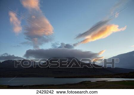 Stock Image - Cloud cover over a mountain at sunset; Iceland. Fotosearch