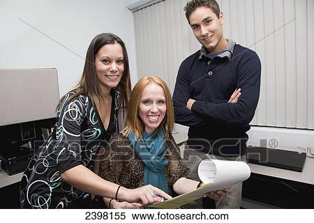 Co-workers assist a person with a disability in the workplace; Edmonton, Alberta, Canada View Large Photo Image Stock Photography - Co-workers assist a person with a disability in the workplace; Edmonton, Alberta, Canada. Fotosearch